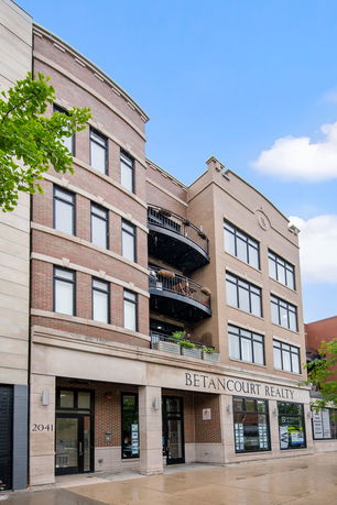 Front view of a multi-story commercial building with large windows and balconies.