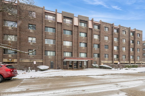 Front view of a multi-story brick building with several windows.