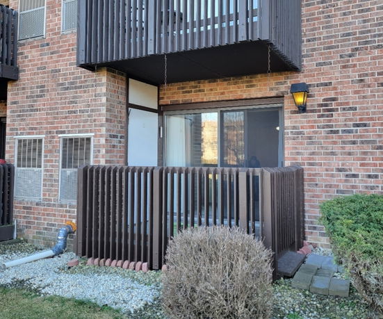 Front view of a brick apartment building with balcony.
