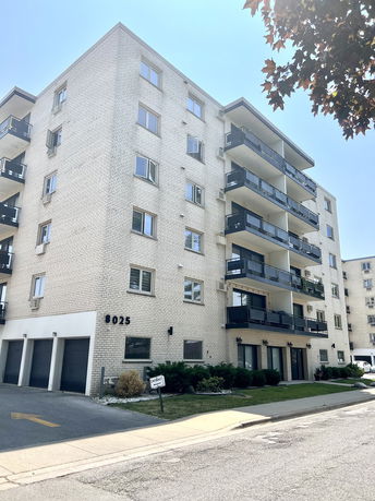 Front view of a multi-story apartment building with balconies.