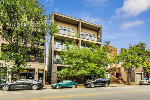 Front view of a multi-story apartment building with balconies.