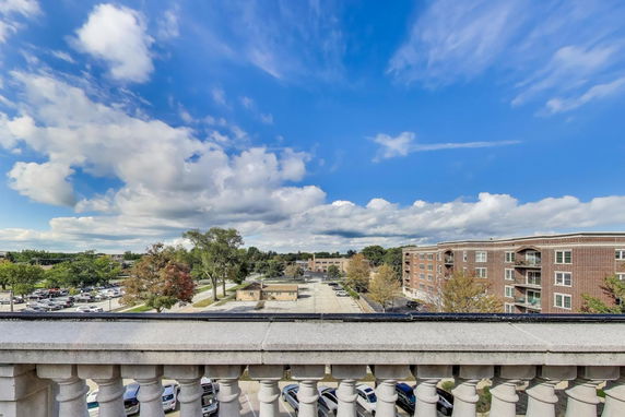Panoramic view showing a residential area with buildings and parking spaces.
