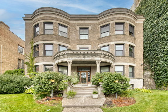 Front view of a three-story building with ornate columned entrance.