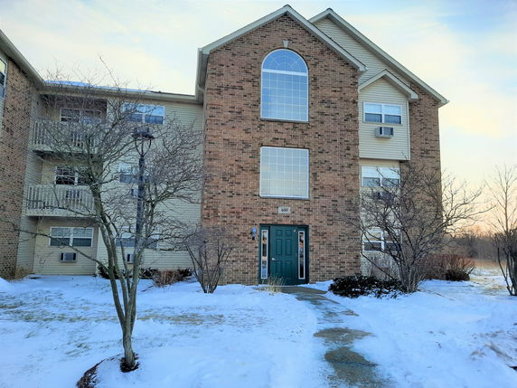Front view of a multi-story building with brick facade and large windows.
