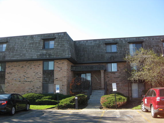 Front view of a brick apartment building with a three-story structure.