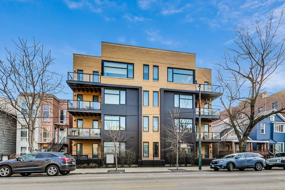 Front view of a modern multi-story apartment building with balconies.