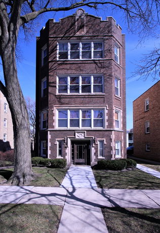 Front view of a multi-story brick apartment building.
