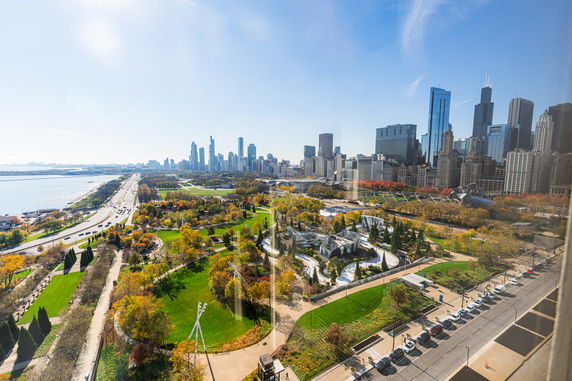 Panoramic view of a cityscape with skyscrapers and a large park in the foreground.