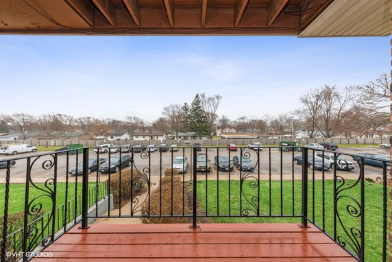 Balcony view of parking area and residential neighborhood.