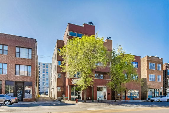 Front view of a multi-story brick building on a city street.