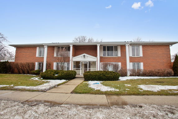 Front view of a two-story brick building with white columns at the entrance.