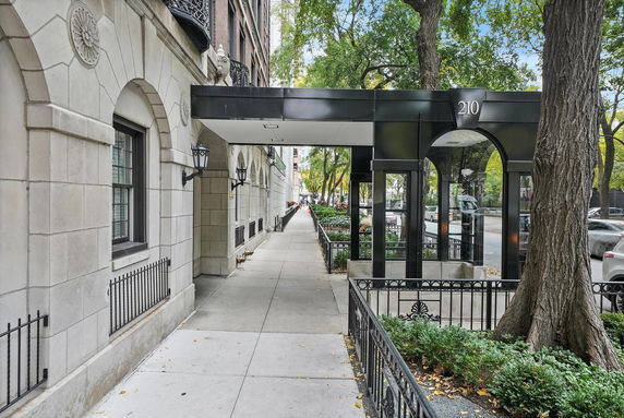 Front view of a multi-story building with decorative entrance and black metal awning.