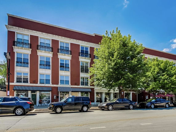 Front view of a multi-story building with large windows and a red facade.