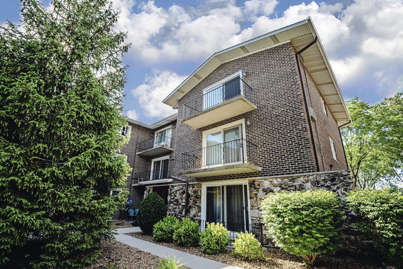 Front view of a multi-story brick building with balconies.