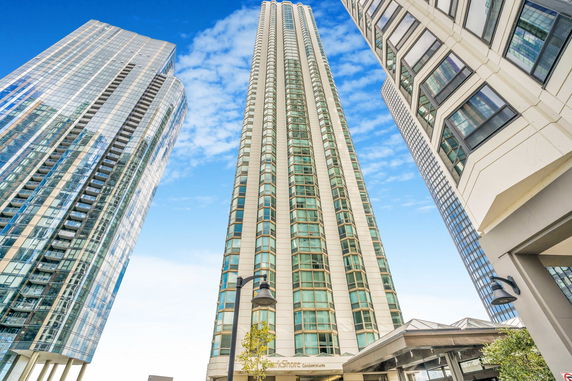 Front view of a tall condominium building with glass windows.