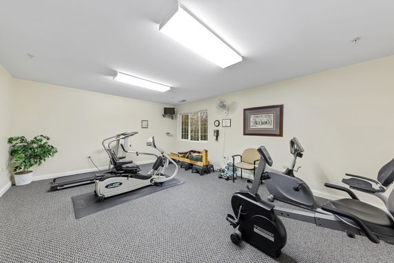 Indoor gym area with exercise equipment including a treadmill and stationary bike.