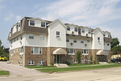 Front view of a multi-story residential building with brick and siding exterior.