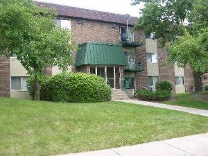 Front view of a multi-story residential building with a green entrance canopy.