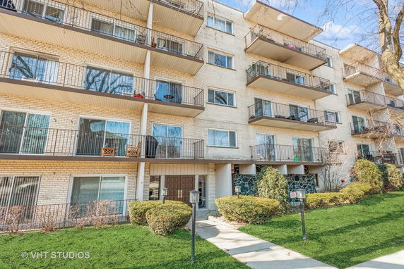 Front view of a multi-story apartment building with balconies.