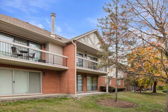Front view of a multi-story building with balconies and a brick exterior.