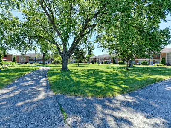 View of residential buildings surrounded by greenery and trees.
