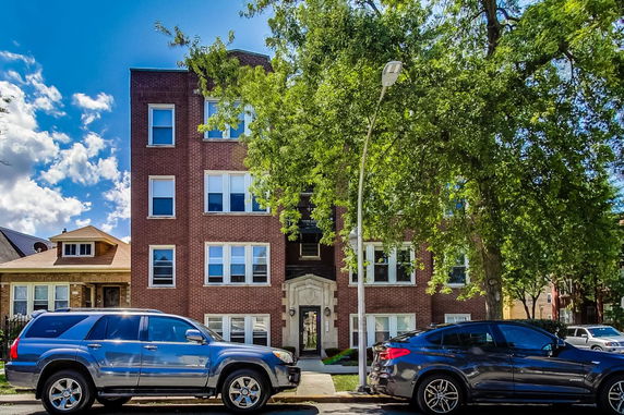 Front view of a multi-story brick building with several windows.