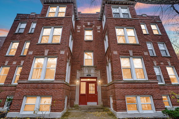 Front view of a multi-story brick building with large windows and a central entrance.