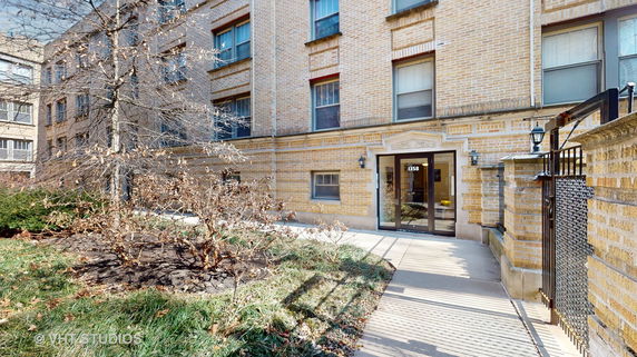 Front view of a brick residential building with glass entrance door.