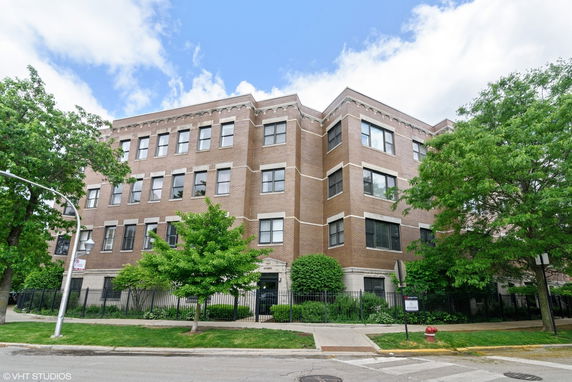 Front view of a four-story brick apartment building.