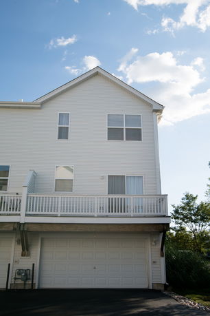 Front view of a multi-story house with a double garage and white exterior.