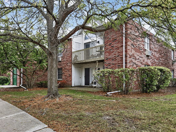 Front view of a two-story brick building with a balcony.