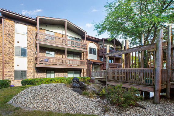 Front view of a multi-story brick apartment building with balconies.