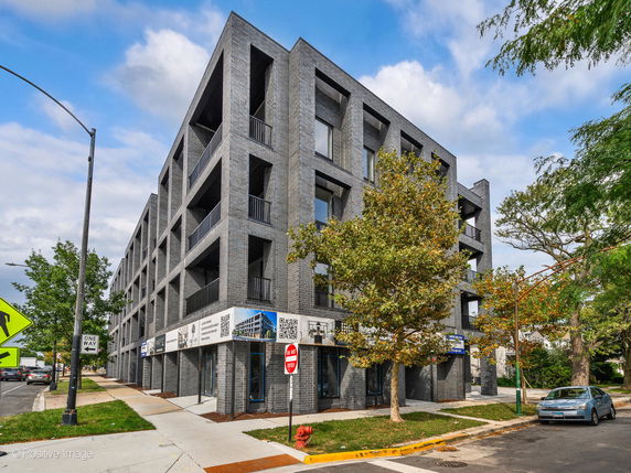 Front view of a multi-story building with modern design and balcony areas.