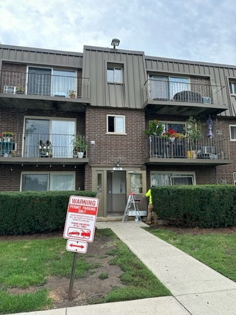 Front view of a three-story apartment building with balconies.