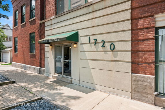 Front view of a brick building with a green entrance awning and the number 1720 displayed.