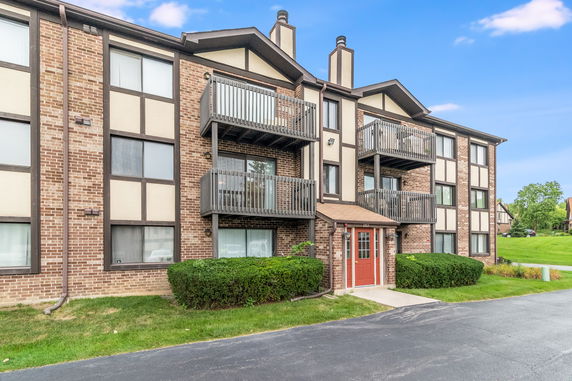 Front view of a multi-story apartment building with balconies.