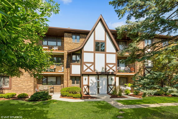 Front view of a three-story building with Tudor-style elements and balconies.