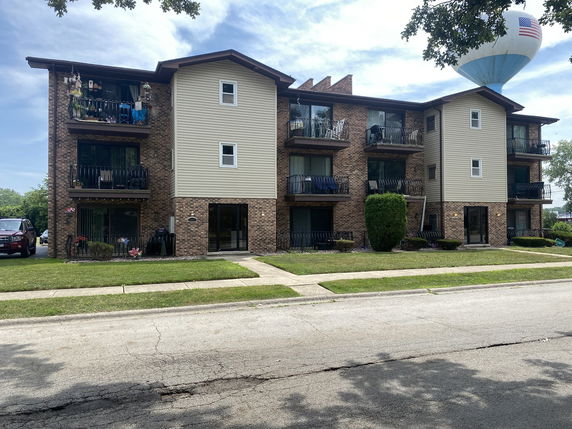 Front view of a three-story apartment building with balconies.