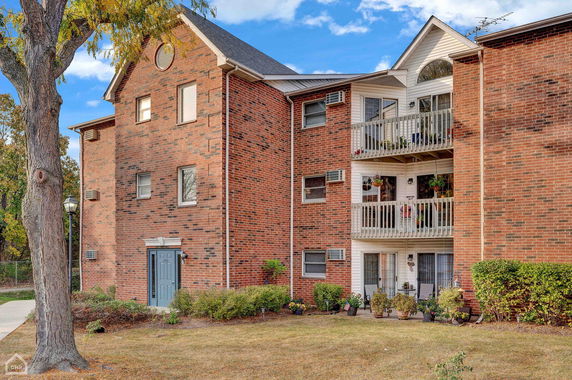 Front view of a brick apartment building with balconies.