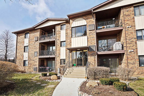 Front view of a multi-story brick building with balconies.