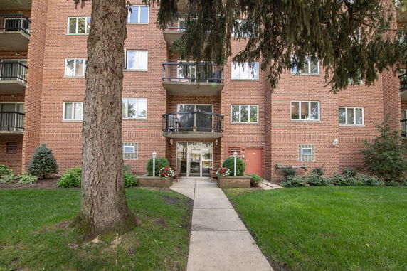 Front view of a multi-story brick apartment building with balconies.