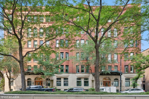 Front view of a multi-story brick building with arched windows.