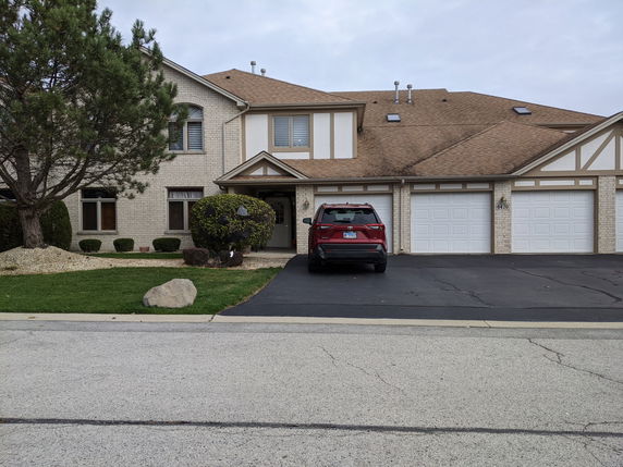 Front view of a two-story house with a double garage and a parked car.