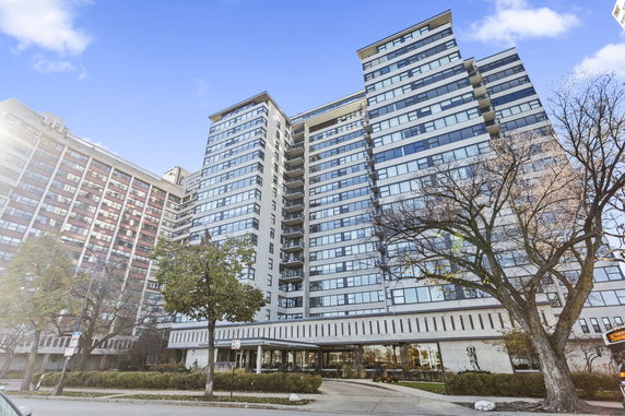 Front view of a multi-story residential building with balconies and large windows.