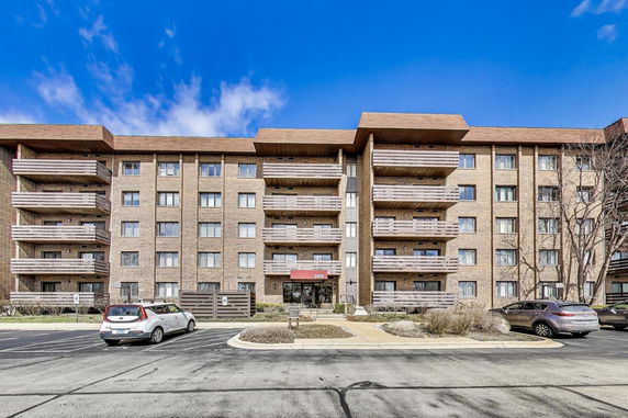 Front view of a multi-story apartment building with balconies.