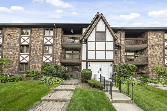 Front view of a multi-story building with a Tudor-style facade and balconies.