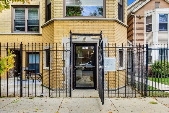Front view of a brick residential building with a gated entrance.