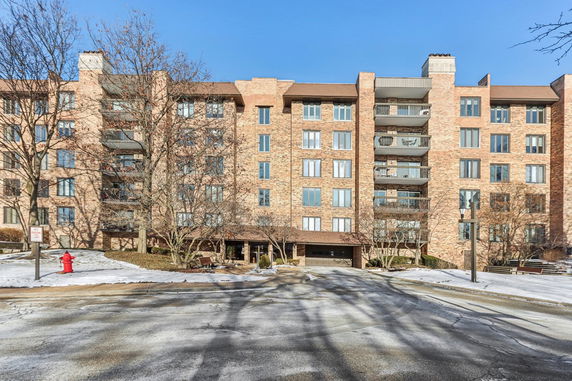 Front view of a multi-story brick residential building with balconies.