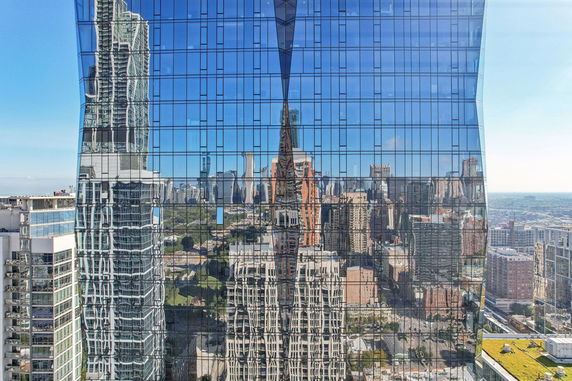 Reflection of cityscape on a glass-fronted skyscraper.