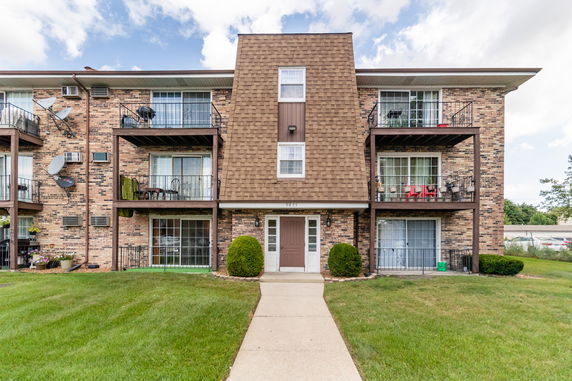 Front view of a multi-story apartment building with balconies.